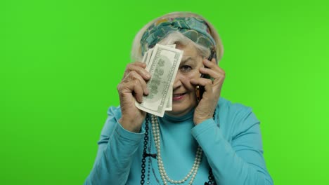 Ältere-Kaukasische-Großmutter-Mit-Geldscheinen,-Die-Auf-Dem-Mobiltelefon-Spricht