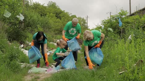 Team-of-nature-activists-in-eco-T-shirts-picking-up-plastic-trash-in-park.-Recycle,-earth-pollution