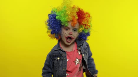 Little-child-girl-clown-in-colorful-wig-making-silly-faces.-Having-fun,-singing,-dancing.-Halloween