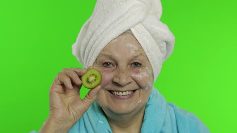 Elderly-grandmother-in-bathrobe.-Old-woman-with-half-of-kiwi-in-her-hand