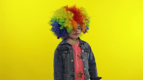 Little-child-girl-clown-in-rainbow-wig-angry-standing-and-waiting-for-something.-Halloween