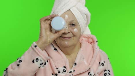 Elderly-grandmother-in-bathrobe.-Old-senior-woman-with-moisturizing-cream-jar