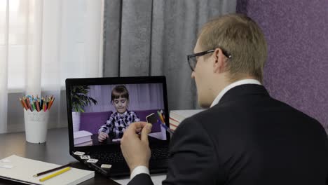 Man-teacher-making-video-call-on-laptop-with-little-pupil.-Distance-education