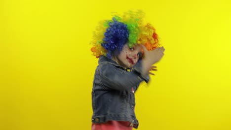 Little-child-girl-clown-in-colorful-wig-making-silly-faces.-Having-fun,-smiling,-dancing.-Halloween