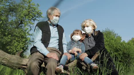 Großeltern-Mit-Enkelin-In-Medizinischen-Masken-Im-Park.-Coronavirus-Quarantäne