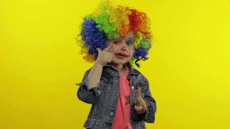 Little-child-girl-clown-in-rainbow-wig-making-silly-faces,-singing,-smiling,-dancing.-Halloween