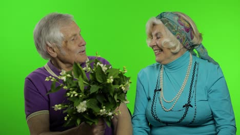 Mature-senior-old-couple.-Grandfather-gives-bouquet-of-flowers-to-grandmother