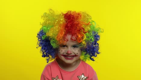 Little-child-girl-clown-in-colorful-wig-making-silly-faces.-Having-fun,-smiling,-laughing.-Halloween