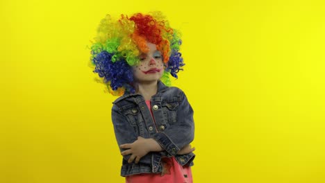 Little-child-girl-clown-in-colorful-wig-making-silly-faces.-Fool-around,-smiling,-dancing.-Halloween
