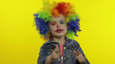 Little-child-girl-clown-in-rainbow-wig-making-silly-faces.-Having-fun,-smiling,-dancing.-Halloween