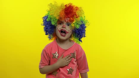 Little-child-girl-clown-in-wig-making-silly-faces.-Singing,-making-shot-signs-from-hands.-Halloween