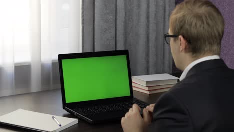 El-Hombre-Tiene-Videoconferencia-En-Una-Computadora-Portátil-Con-Pantalla-Verde.-Trabajo-A-Distancia-En-Línea