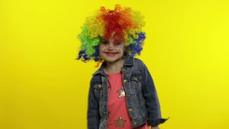 Child-girl-clown-in-colorful-wig-dancing-with-money-dollar-cash-banknotes.-Fool-around,-smiling