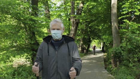 Aktiver-älterer-Alter-Mann-In-Maske-Trainiert-Nordic-Walking-Im-Park-Während-Der-Quarantäne