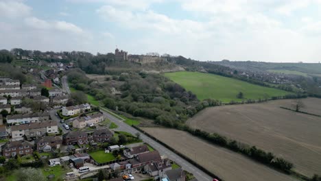 Approaching-Bolsover-Castle-Derbyshire-from-the-air-across-fields-on-bright-but-cloudy-day