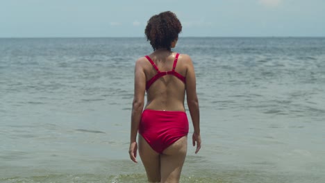 Der-Reiz-Eines-Tropischen-Strandes-Wird-Noch-Verstärkt,-Wenn-Eine-Latina-Schönheit-Mit-Lockigem-Haar-Selbstbewusst-Einen-Sexy-Bikini-Trägt