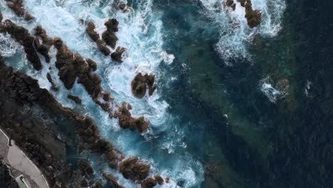 volcanic-pools-of-Porto-Moniz-in-Madeira-Potrugal-fottage-with-drone-of-cliffs,-ocean,-atural-bathing-spots,-houses-filmed-at-sunset