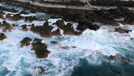volcanic-pools-of-Porto-Moniz-in-Madeira-Portugal-footage-with-drones-of-cliffs,-ocean,-natural-bathing-spots,-and-houses-filmed-at-sunset