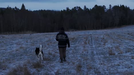 Indre-Fosen,-Trondelag-County,-Norway---A-Man-Strolling-with-His-Dog-on-the-Farm---Tracking-Shot