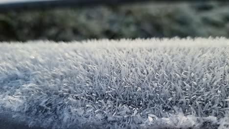 Frozen-frosty-spikes-natural-pattern-close-up-coating-wooden-fence-in-cold-winter-parkland