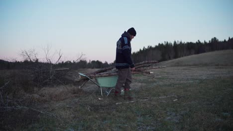 A-Man-is-Moving-the-Cut-Logs-with-a-Wheelbarrow---Static-Shot