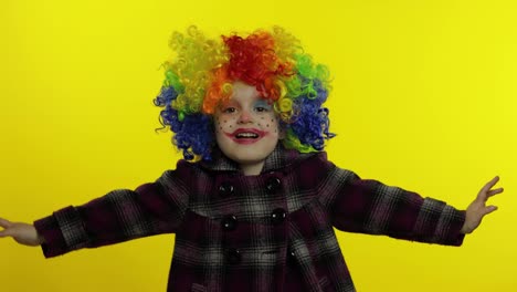 Little-child-girl-clown-in-colorful-wig-making-silly-faces,-having-fun,-smiling,-dancing.-Halloween