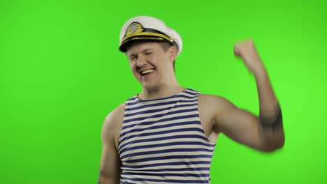 Young-sailor-man-celebrates-yelling-emotionally-and-raises-his-hands.-Seaman-guy