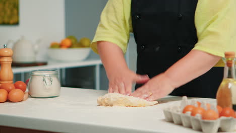 Woman-hands-kneading-dough-on-table