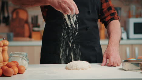 Man-sifting-flour-on-dough