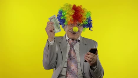 Clown-Geschäftsmann-Unternehmer-Chef-Erhält-Geldeinkommen,-Während-Er-Sein-Smartphone-Nutzt