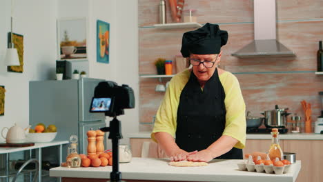 Old-woman-recording-food-video-in-kitchen