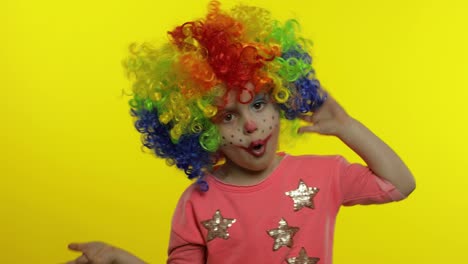 Little-Child-girl-clown-in-wig-making-silly-faces.-Having-fun,-smiling,-showing-tongue.-Halloween