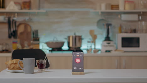 Phone-with-intelligent-software-placed-on-table-in-kitchen-with-nobody-in