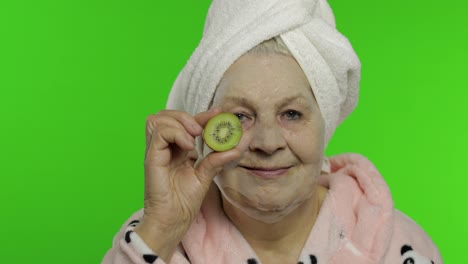 Elderly-grandmother-in-bathrobe-with-bubble-face-mask.-Old-woman-with-kiwi