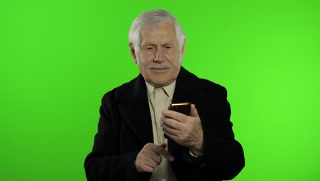 Anciano-Y-Elegante-Abuelo-Caucásico-Usando-Una-Aplicación-De-Redes-Sociales-En-Un-Teléfono-Inteligente