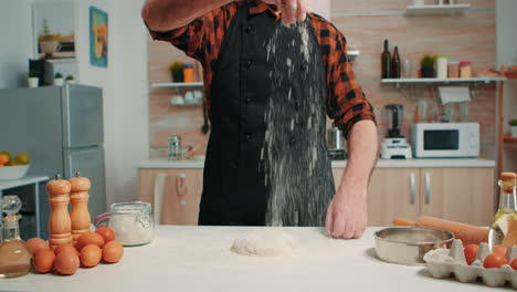 Bakery-man-sifting-flour,-preparing-bread-dough