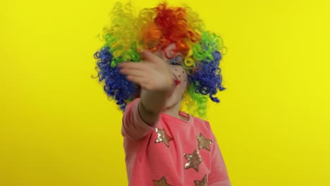 Little-child-girl-clown-in-colorful-wig-waving-hands,-having-fun,-smiling.-Halloween