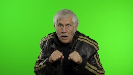 Elderly-caucasian-grandfather-rocker-man-shows-fist-fight.-Chroma-key-background