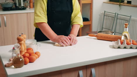 Woman-kneads-the-dough-on-table
