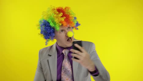 Clown-businessman-entrepreneur-boss-in-wig-making-selfies-using-smartphone