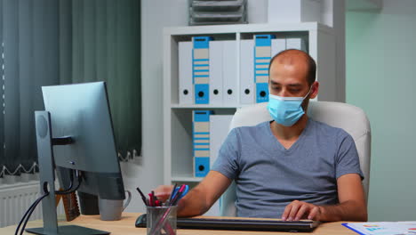 Manager-with-face-mask-working-in-office