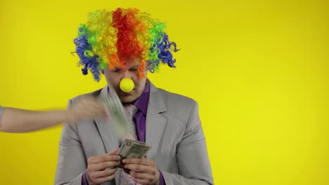 Clown-businessman-entrepreneur-counts-money-income.-Hand-steals-cash-from-man