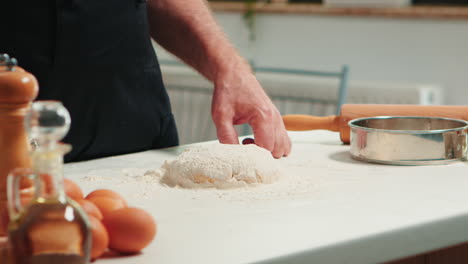 Baker-adding-flour-on-the-pile-by-hand