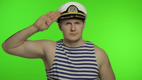 Young-sailor-man-salutes-with-hand-to-camera.-Seaman-guy-in-sailor's-vests