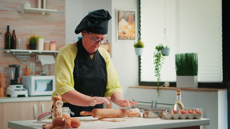 Woman-chef-using-wooden-rolling-pin