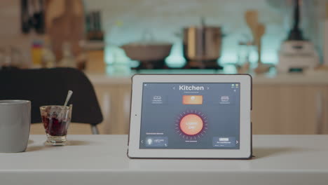 Tablet-with-intelligent-software-placed-on-table-in-kitchen-with-nobody-in