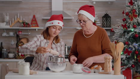 Senior-woman-teaching-grandchild-who-to-straing-flour-ingredient-in-bowl