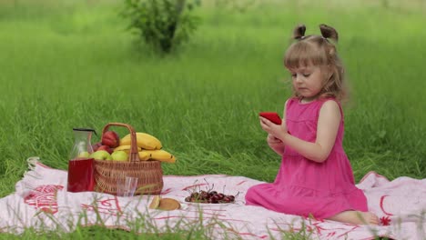 Weekend-at-picnic.-Girl-on-grass-meadow-play-online-games-on-mobile-phone.-Social-network,-chatting