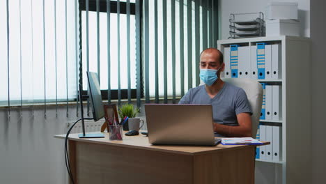Man-with-mask-having-online-meeting