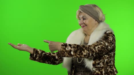 Elderly-caucasian-grandmother-woman-pointing-at-something-with-hand.-Chroma-key
